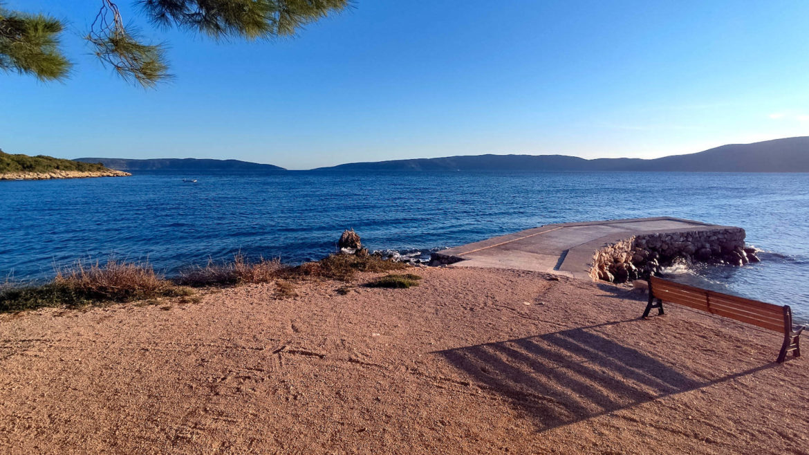 Krk, blaues Meer und eine einsame Sitzbank. Kroatien