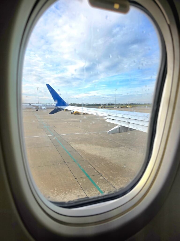Blick aus dem nassen Flugzeugfenster am Flughafen Wien.