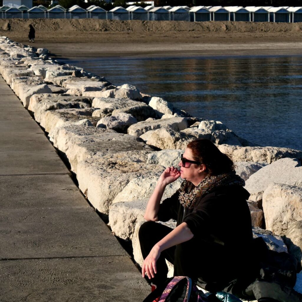 Nicole Schwarzbier sitzt auf einem Steg am Strand von Lido in Venedig