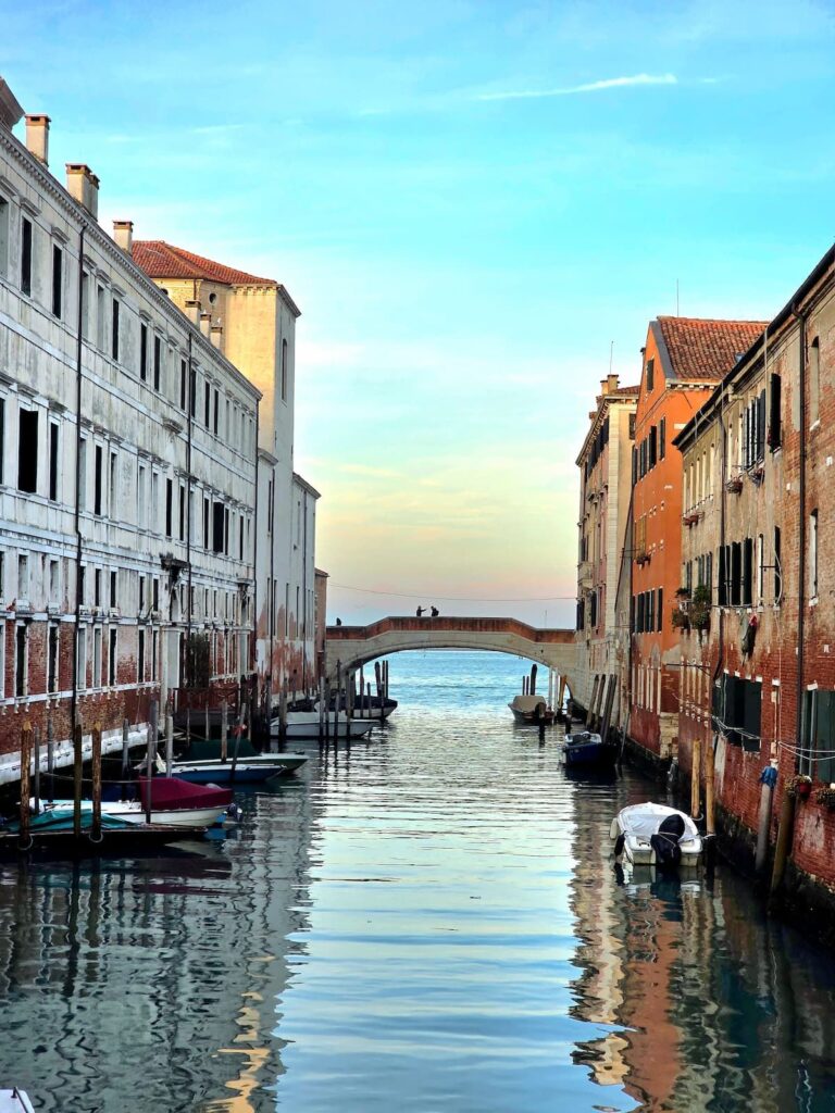 Ein Kanal und eine Brücke in Venedig bei Abenddämmerung