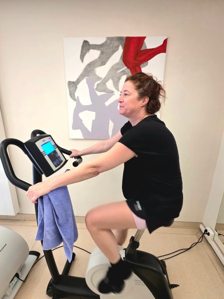 Nicole Schwarzbier beim Ausdauertraining im Josefinenhof vor dem Bild vom Maler Ondrej Kohout