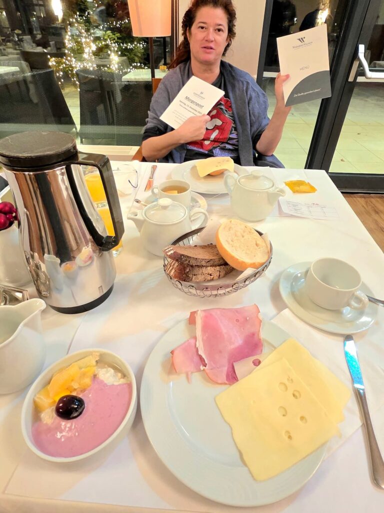 Nicole Schwarzbier beim Frühstück im Josefinenhof in Warmbad Villach mit Morgenpost und Menükarte