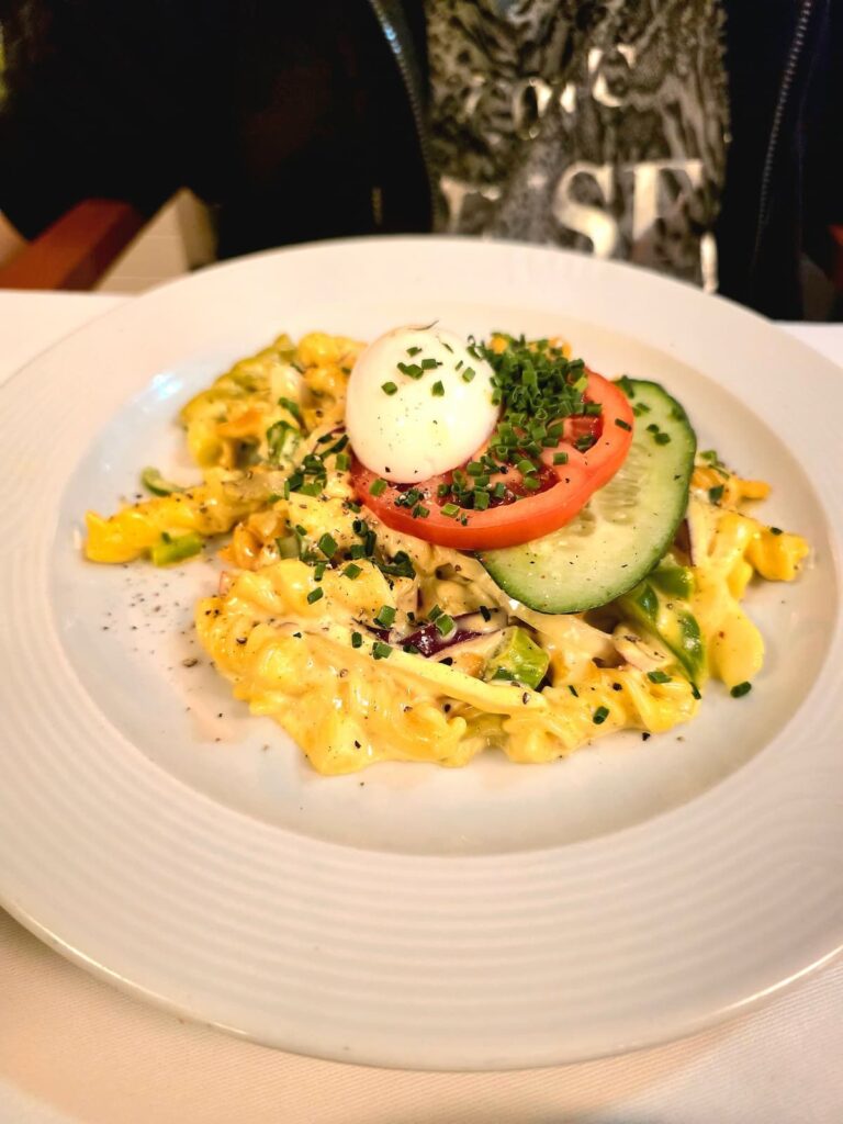 Nudelsalat mit Curry und hartgekochtem Ei garniert